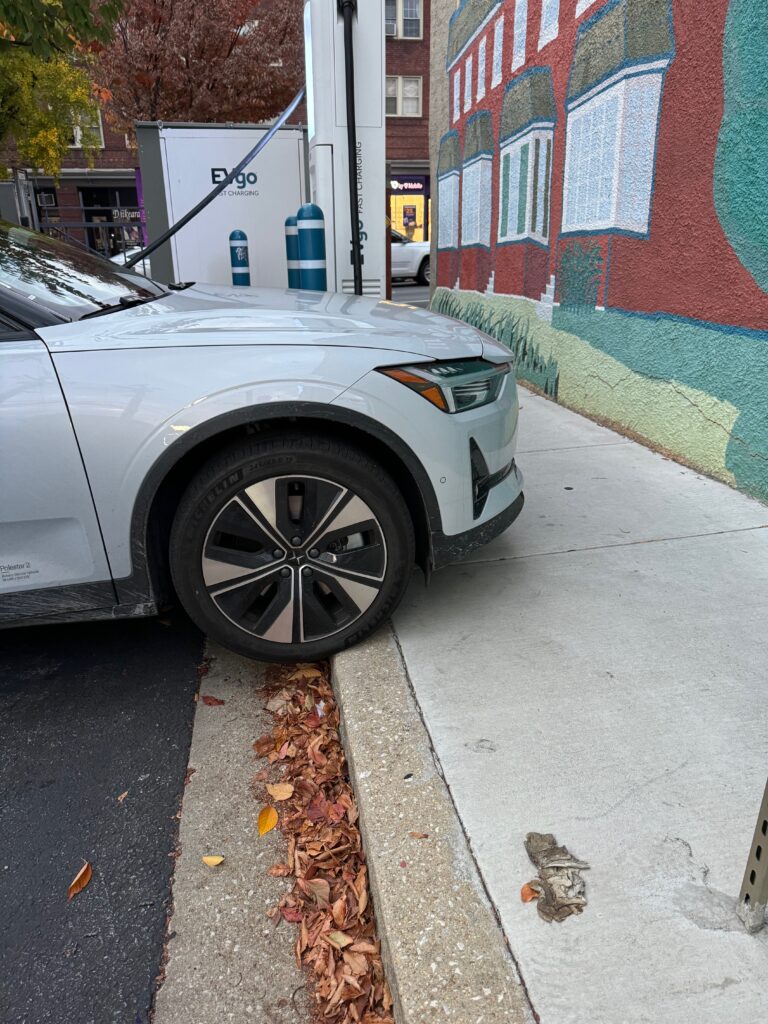 An EV parked on the curb because the charging cable was too short